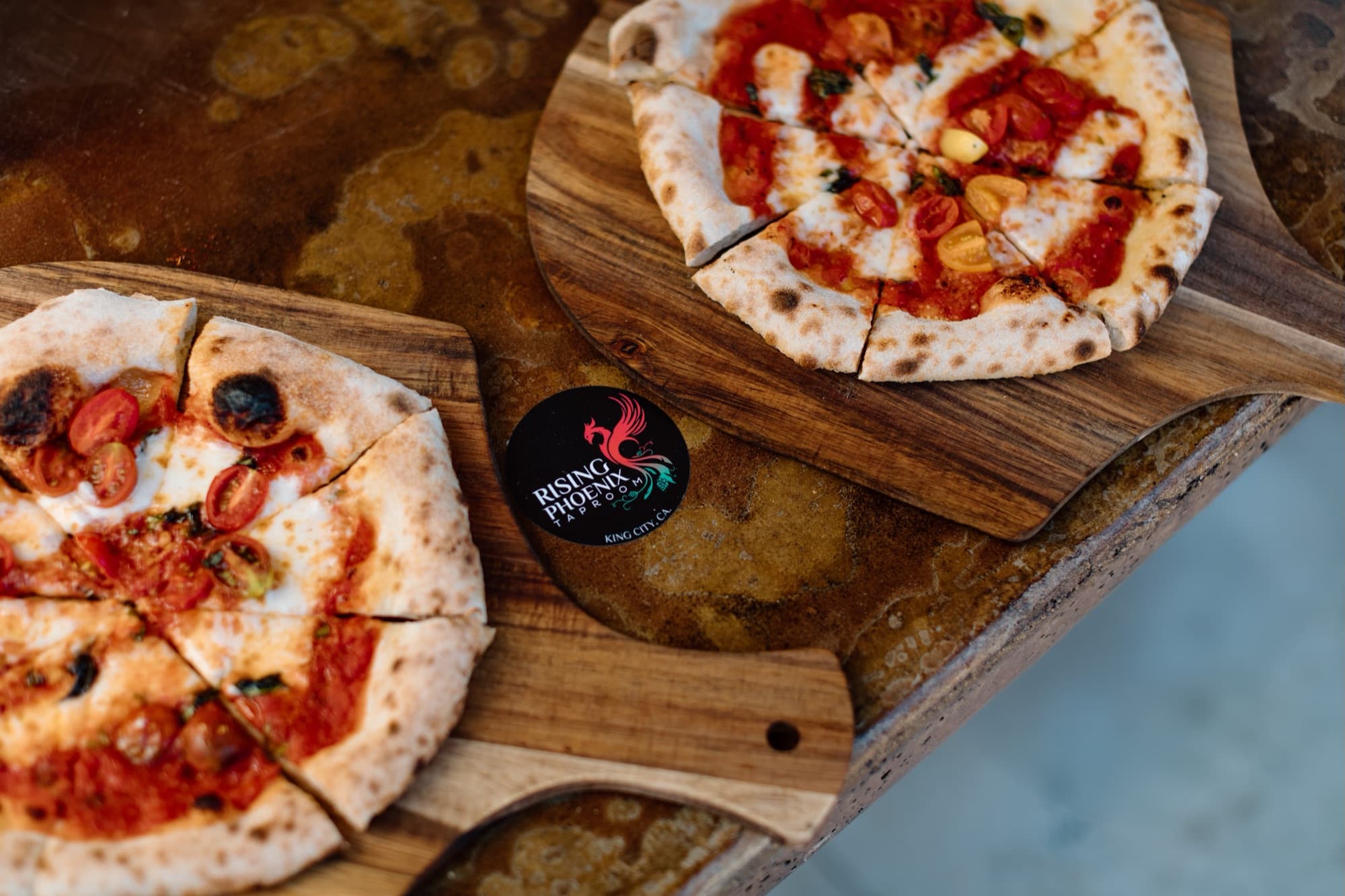 Two wood-fired pizzas with the branded coaster