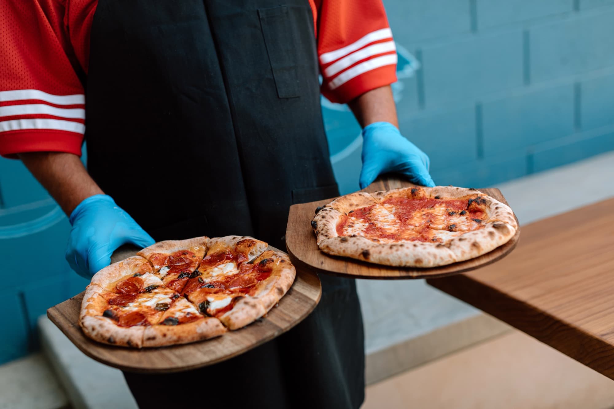 Two wood boards of pizza at the mural